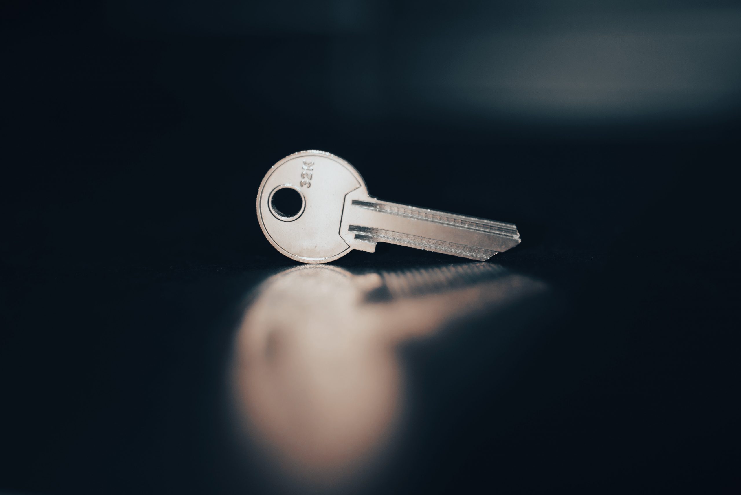 a key on a semi reflective surface depicting a key necessary for encryption